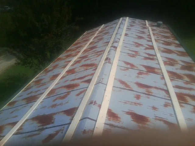 Rusted metal roof panels with new wood purlins before replacement — Storm Damage Roof Repair in Tarawa Terrace by Roofing Brothers