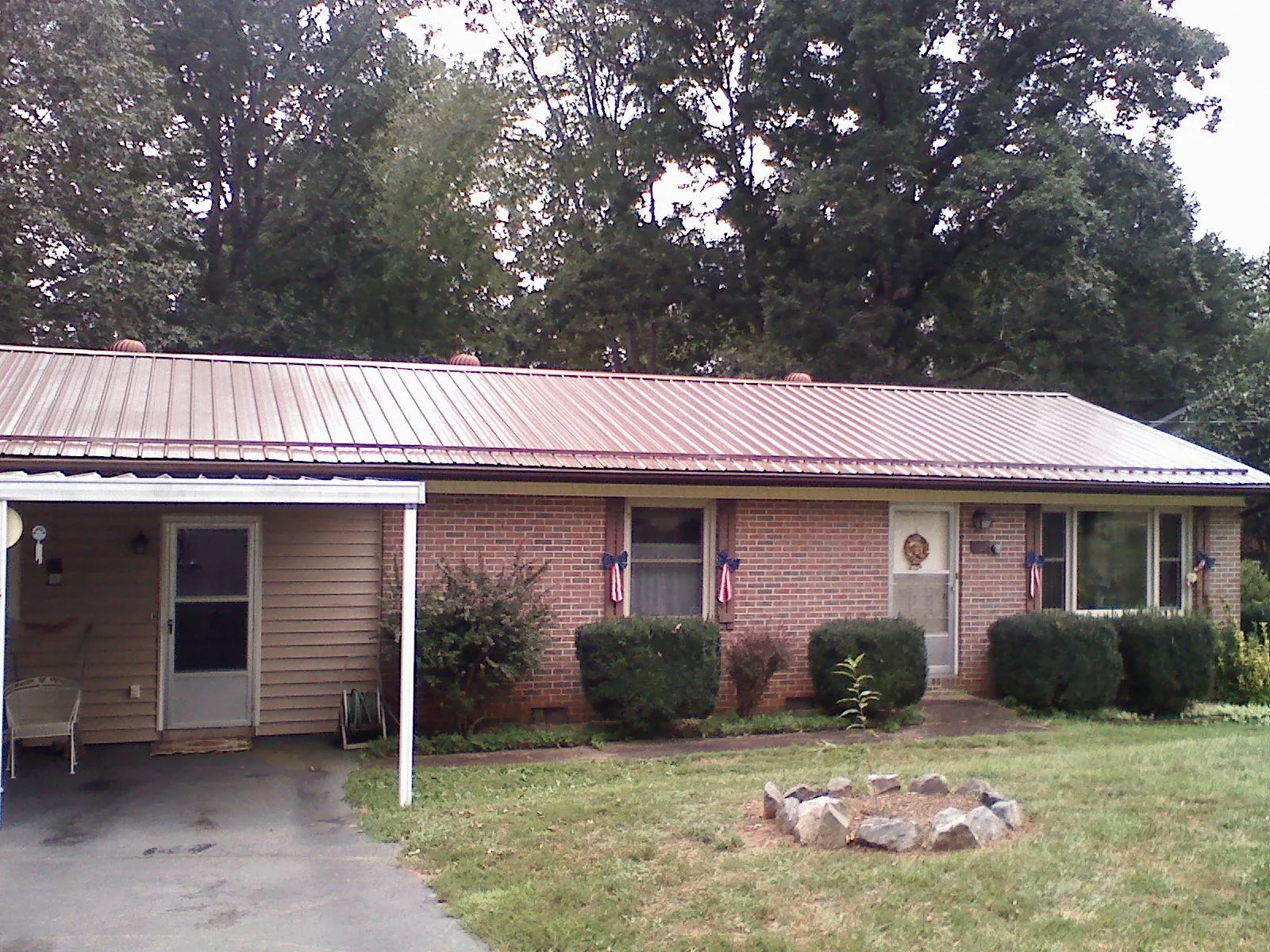 Bronze metal roof and carport on a brick ranch home — Roof Repair work by our crew in Tarawa Terrace